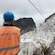 A tour guide wearing a safety vest looking out at a marble quarry